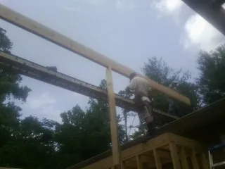 Carpenter setting a ridge beam over a new addition frame — Ice Dam Removal by Roofing Brothers in Hubbardsville
