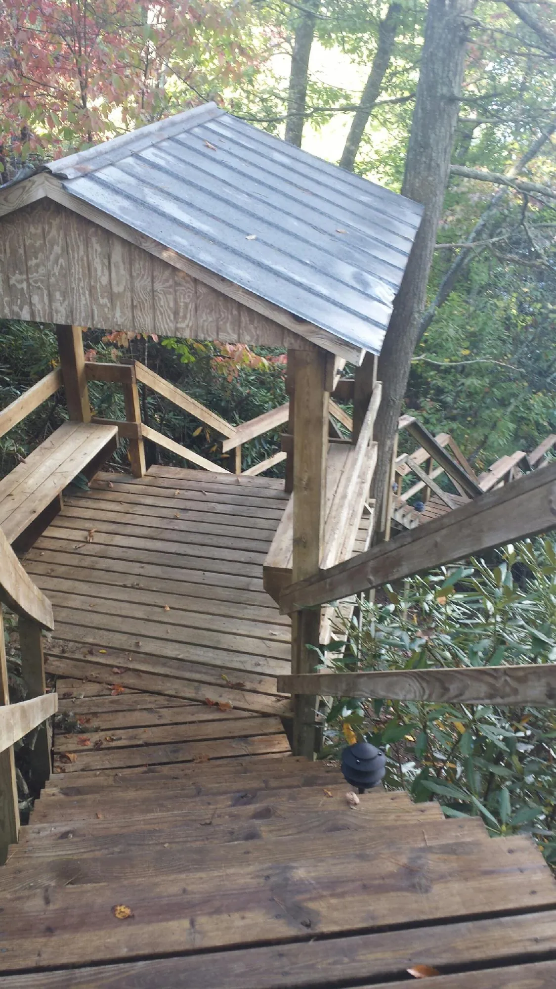 Metal roofed shelter over wooden steps on a wooded walkway — Skylight Repair & Installation work by our crew in Hubbardsville
