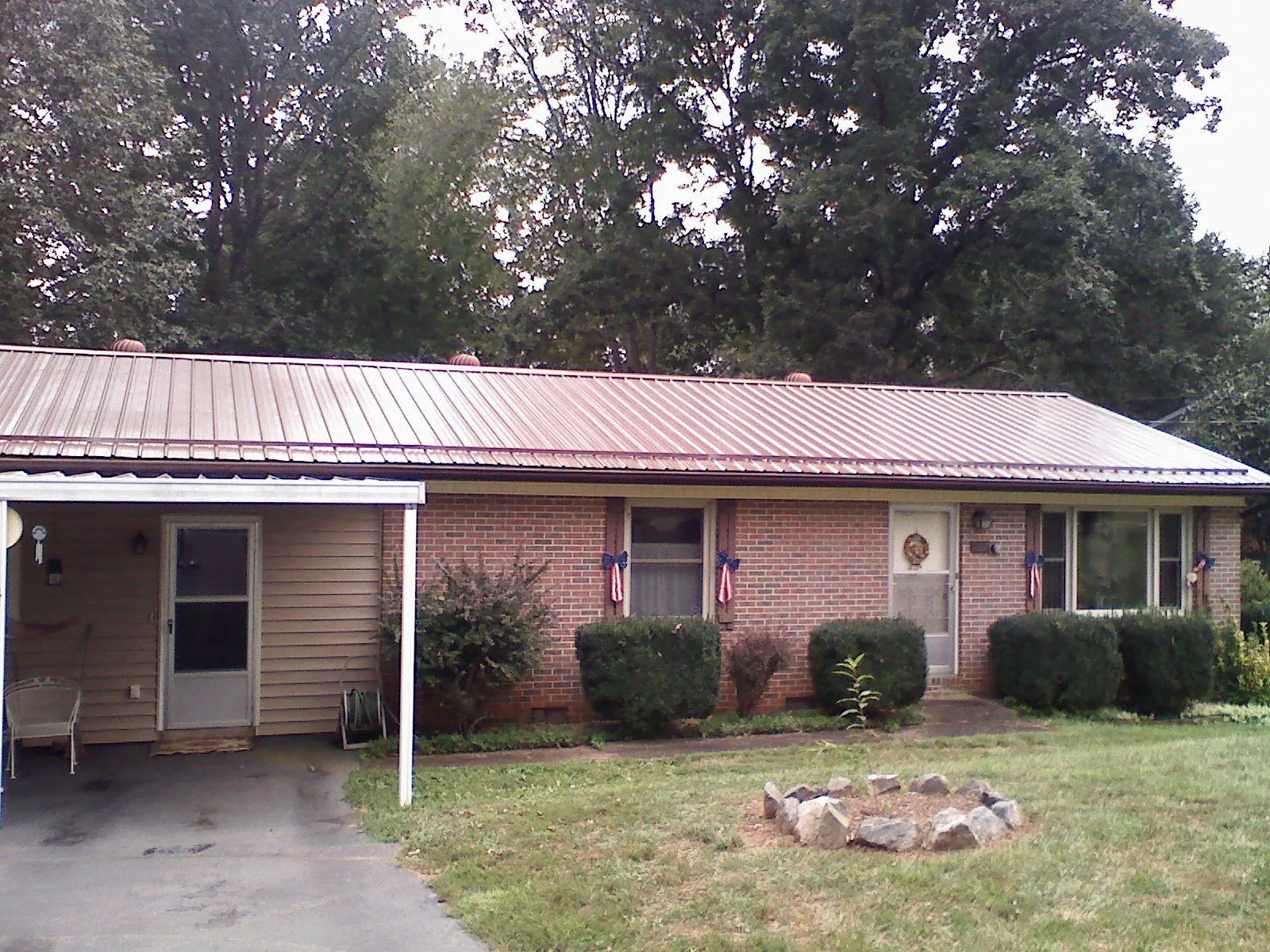 Bronze metal roof and carport on a brick ranch home — Roof Repair work by our crew in Hubbardsville